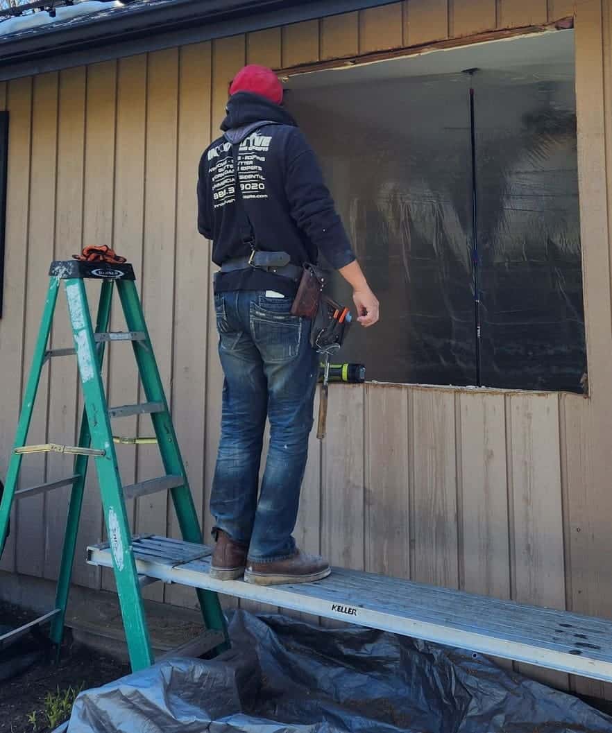 IHC installer in branded sweatshirt installing a new window