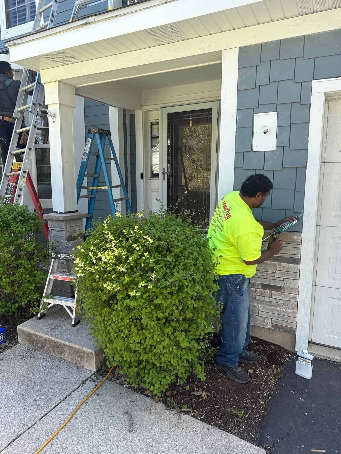 Installer caulking James Hardie shake siding with Versetta Stone