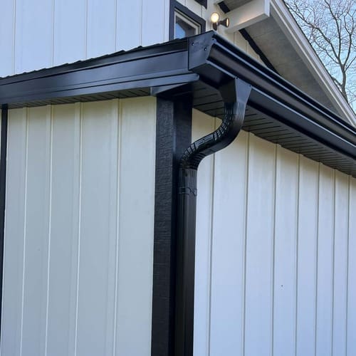 New White Fiber Cement Siding and Black Gutters