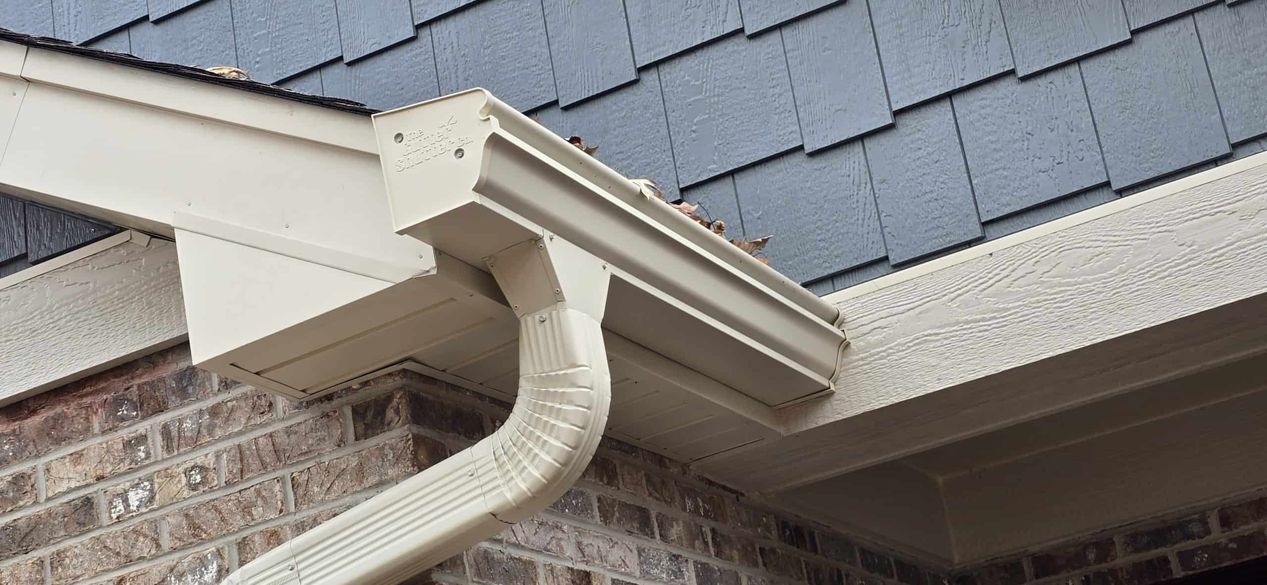 Close-up of GutterShutter one-piece aluminum gutter and hood system installed on a home