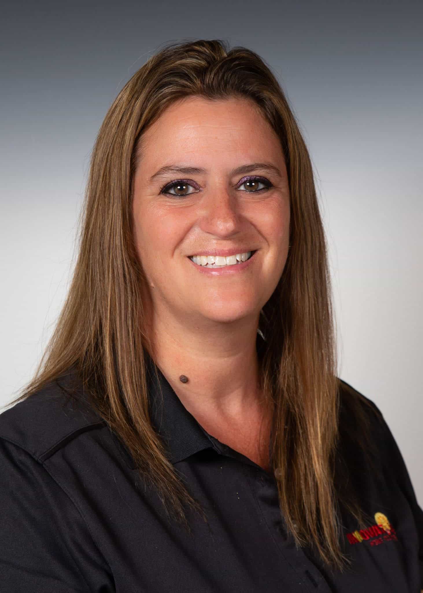 Woman smiling in black uniform representing Innovative Home Concepts, Inc.