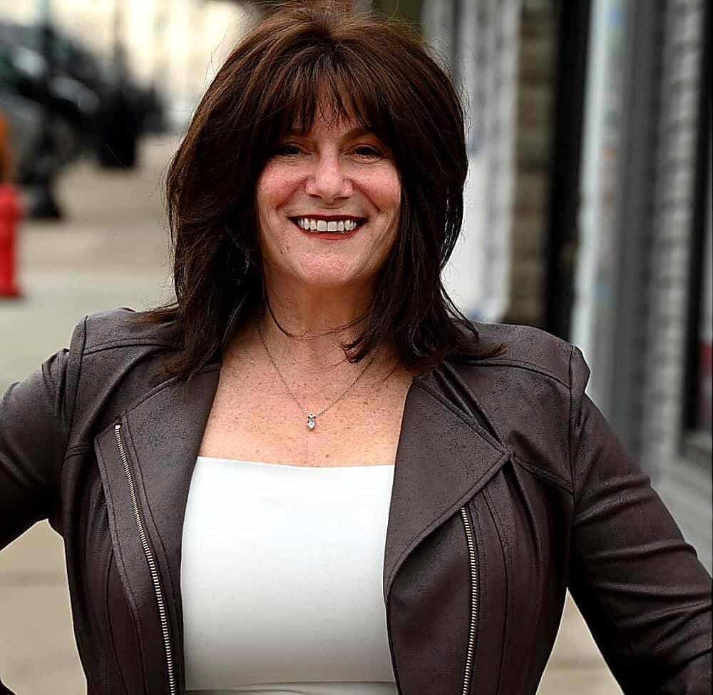 Professional woman smiling outdoors, representing innovative home concepts.