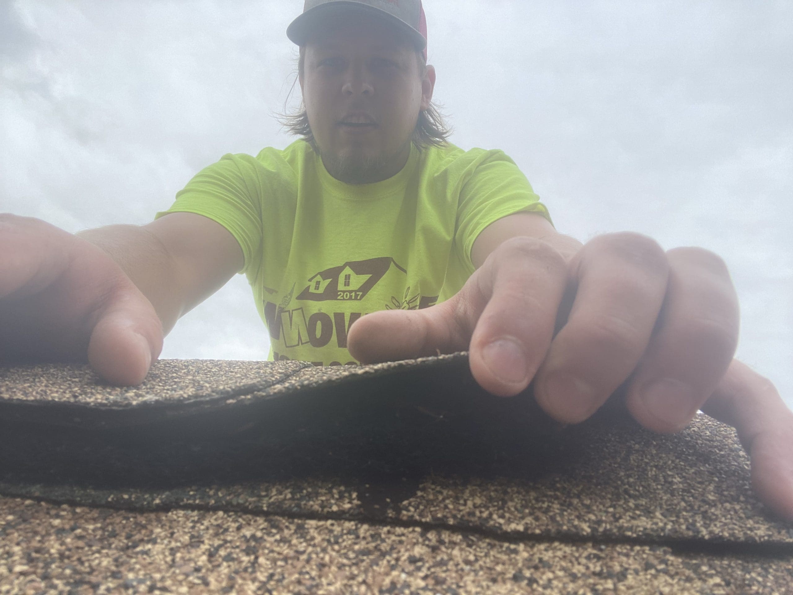 IHC team member inspecting roof shingles for damage in McHenry County
