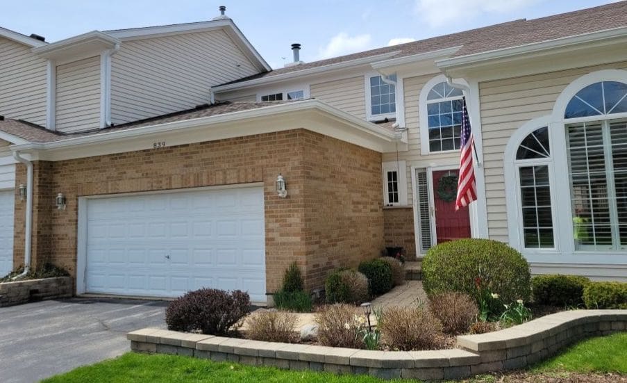 GutterShutter system installed on townhouses in McHenry County showing the curved hood design