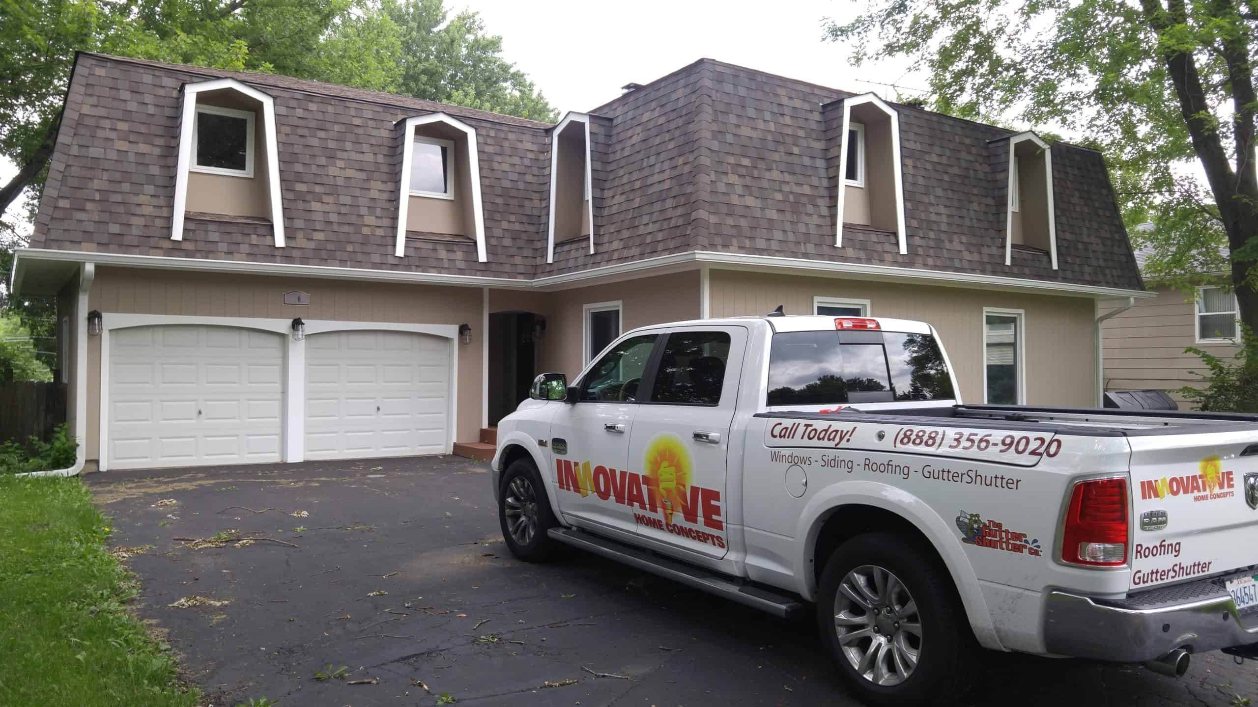 Innovative Home Concepts truck in front of a completed mansard roof and gutter installation
