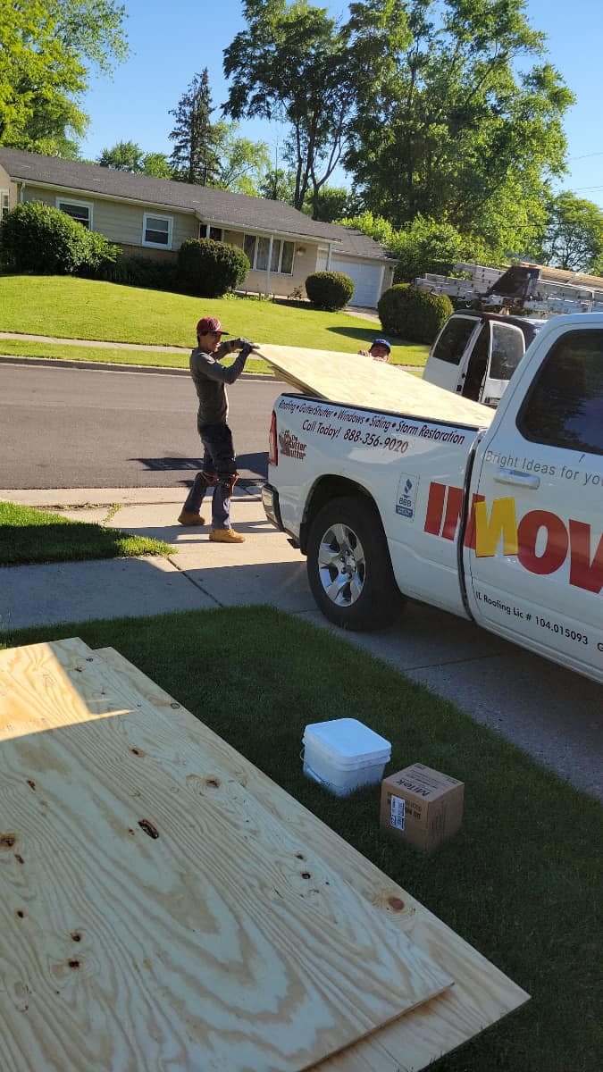 IHC crew unloading plywood for a roof repair project in McHenry County