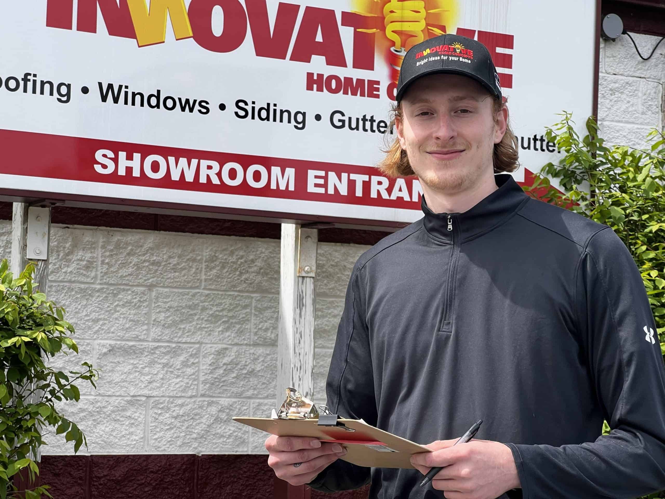 Skyler Wilborn standing by the Innovative Home Concepts showroom sign