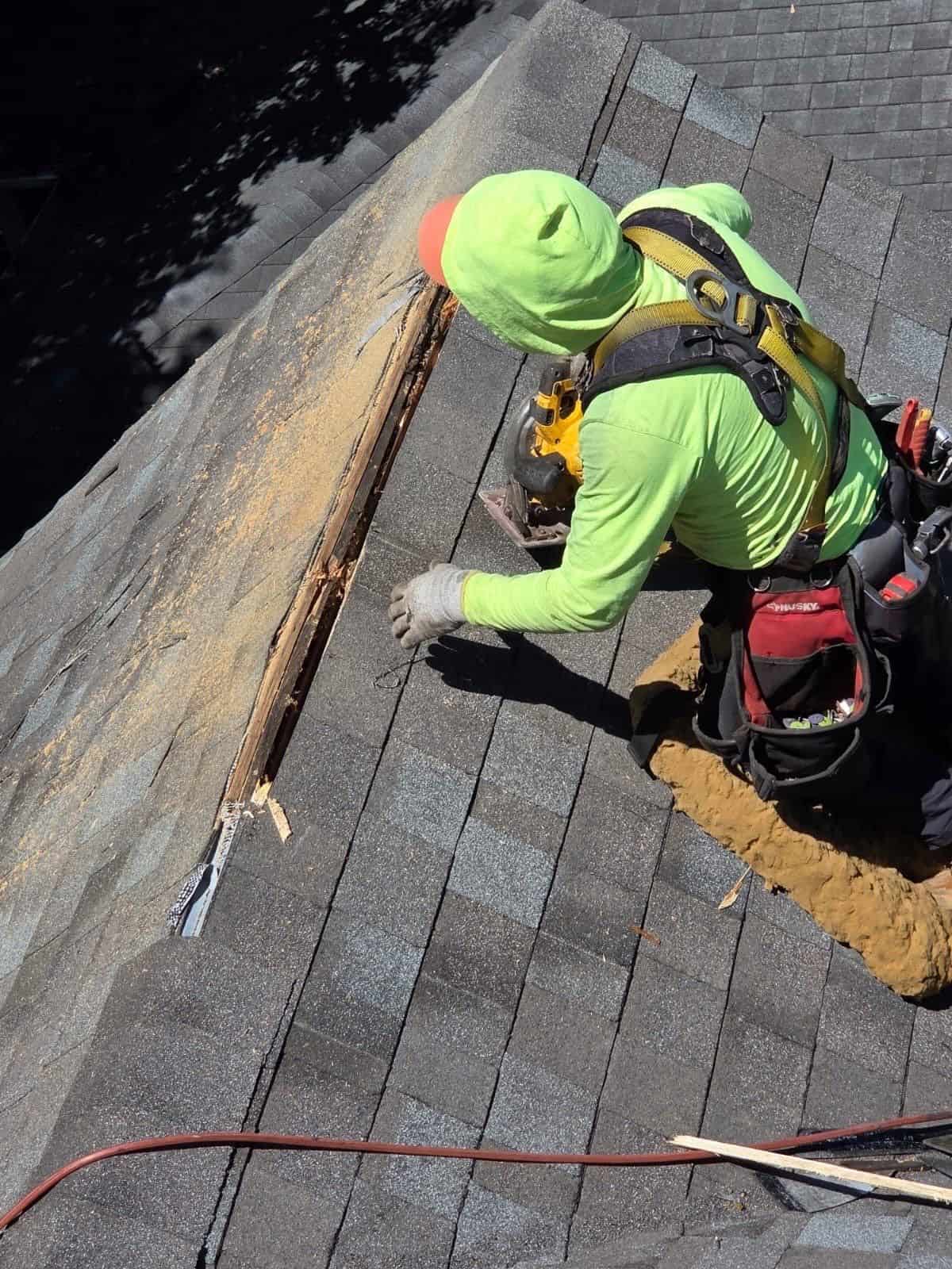 IHC crew member cutting in ridge vent during roof installation