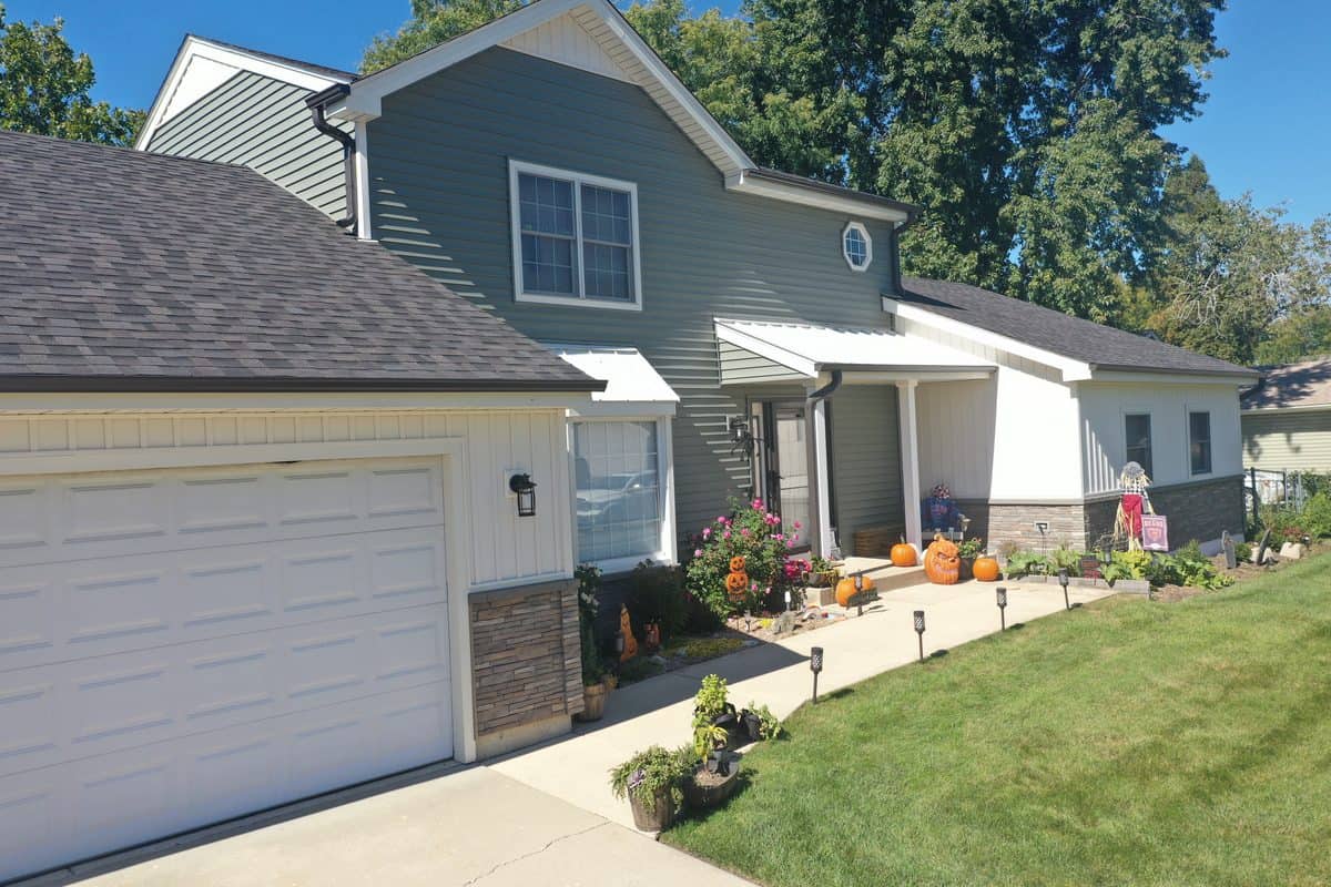 Completed siding installation on a home in McHenry County with gray siding and landscaping