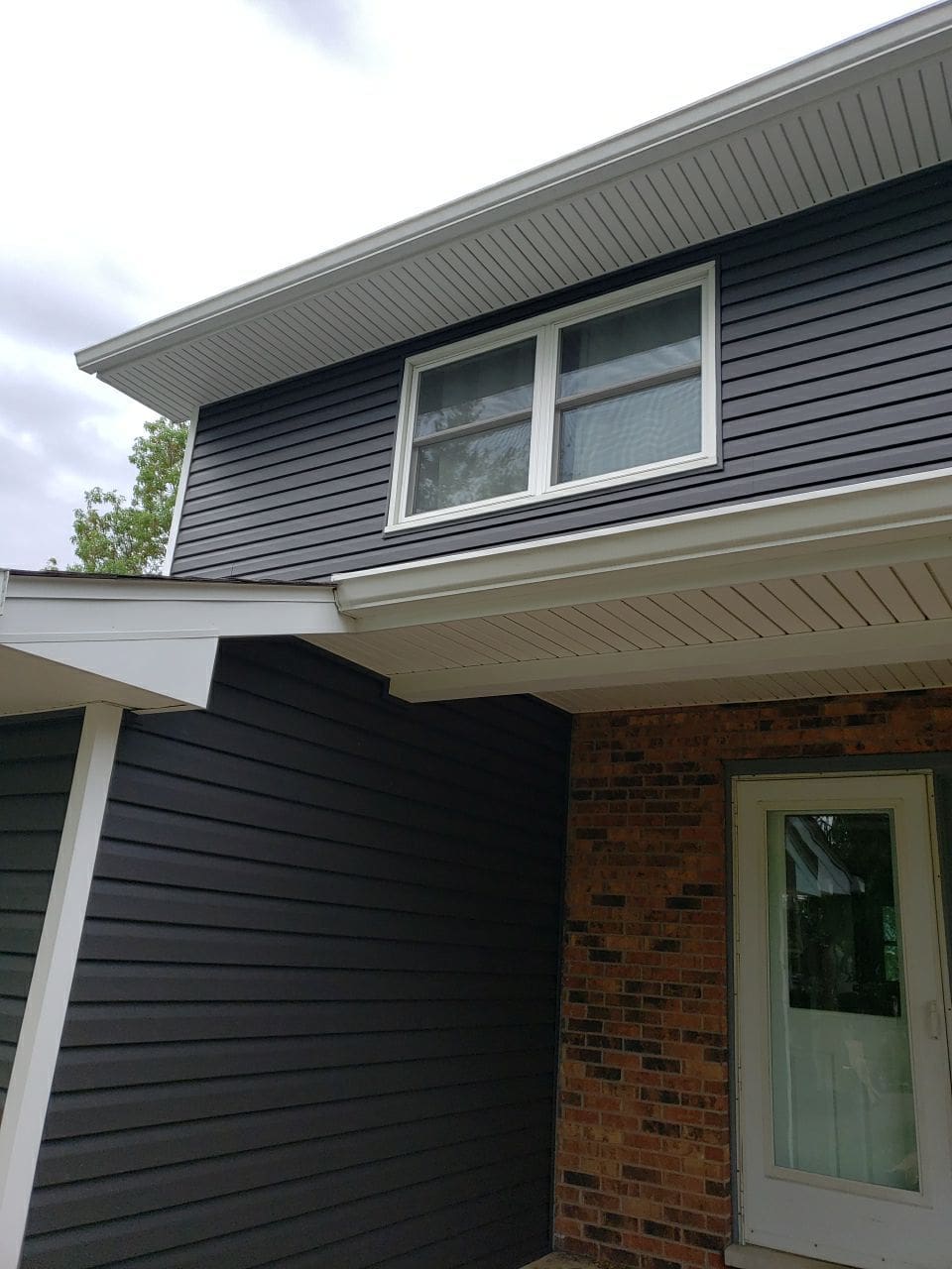 New charcoal vinyl siding with white trim and new gutters at Mark Ct, Woodstock IL
