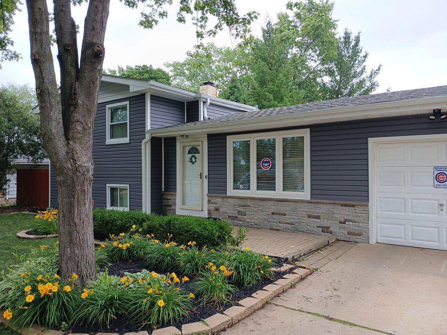 Abbington Drive Crystal Lake IL after — charcoal vinyl siding with new gray stone accent on porch and bay window, white trim, new gutters