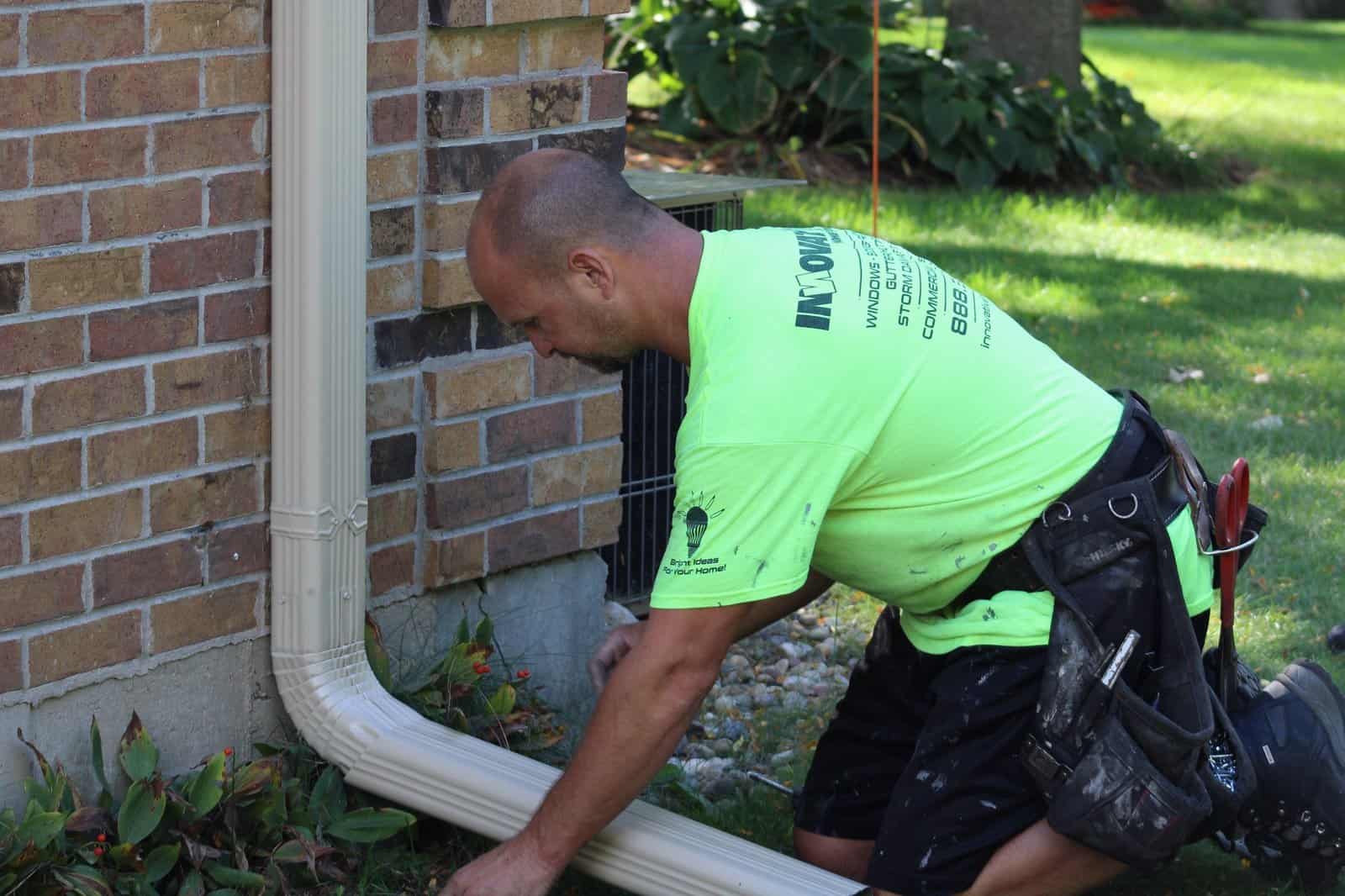 IHC technician installing seamless gutter on a McHenry County home