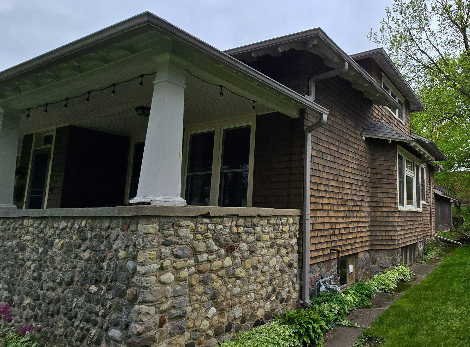 Lincoln Avenue Woodstock IL before — weathered brown cedar shake siding on craftsman bungalow with fieldstone foundation