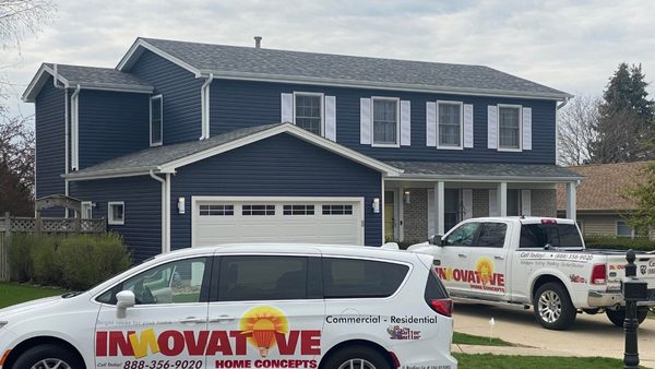 Innovative Home Concepts trucks parked in front of a Crystal Lake siding job