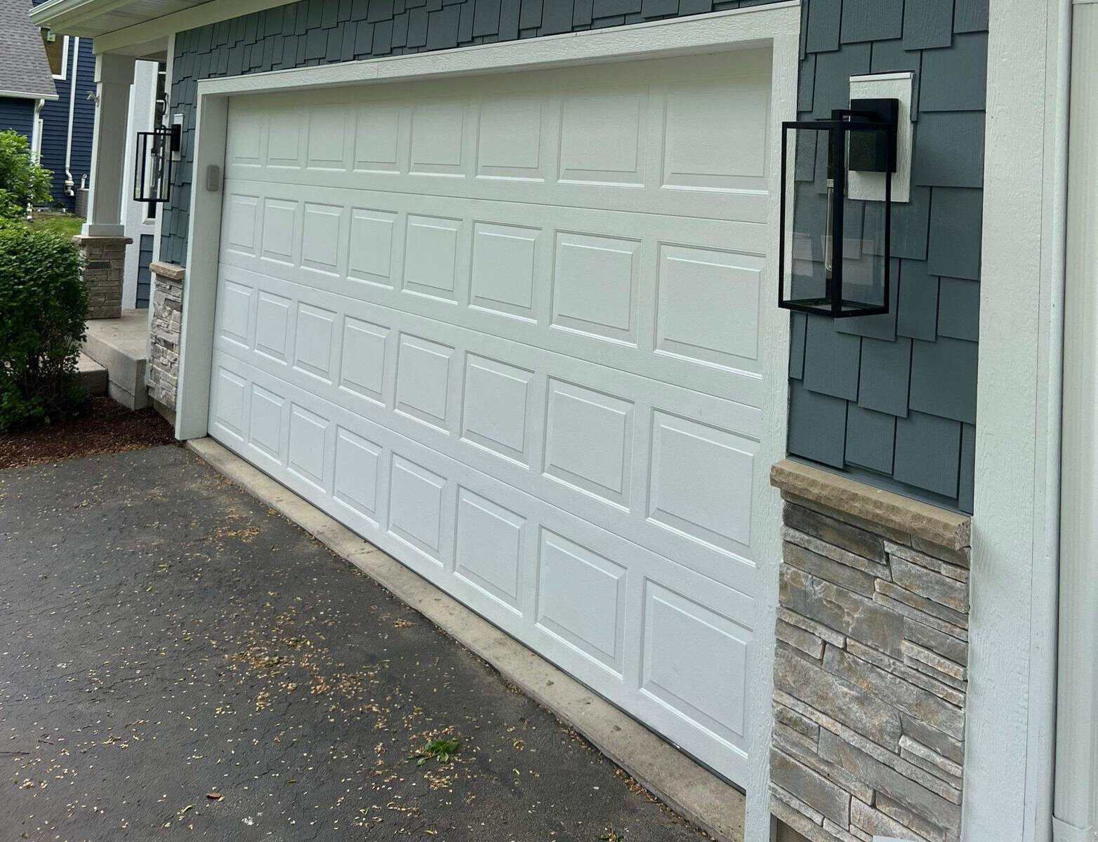 Versetta Stone wainscot installed on garage base and porch column with blue Hardie shake siding